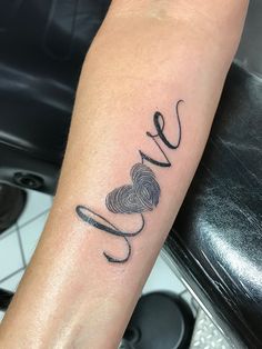 a person with a tattoo on their arm that reads love and is holding a fishing hook