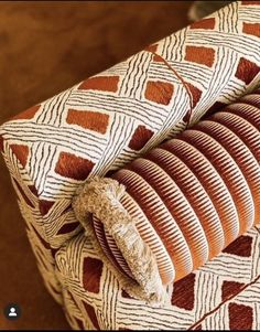 an orange and white cushion on top of a wooden table