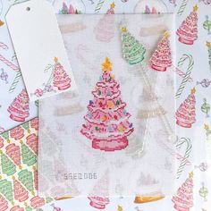 cross stitch christmas tree with tags on it