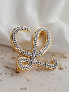 Elevate your accessory game with our Diamond Inlaid Letter Pearl Brooch and make a statement of personalized elegance. Embrace the sparkle of diamonds, the luster of pearls, and the timeless appeal of personalized jewelry with this exquisite brooch that is sure to become a cherished piece in your collection. Metal: 18ct Recycled white Gold Plated On Brass Dimensions:45*45mm Weight: 23g Elegant Personalized Silver Brooches, Personalized Elegant Wedding Brooches, Elegant Personalized Wedding Brooches, Edison Pearls, Letter Design, Pearl Brooch, Tiger Eye Stone, Monogram Design, Pearl Gemstone