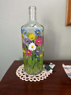 a glass bottle sitting on top of a wooden table next to a lace doily