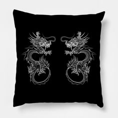 a black and white pillow with two dragon designs on the front, both facing each other