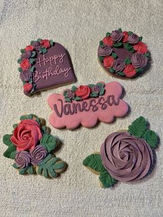 decorated cookies on a towel with happy birthday written in the middle and flowers around them