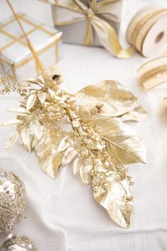 a table topped with lots of gold and silver decorations on top of a white table cloth