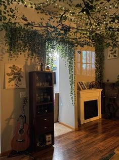 the living room is decorated with greenery and string lights hanging from the ceiling over the fireplace