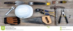 construction tools laid out on top of a wooden table with hammers, wrenches and gloves