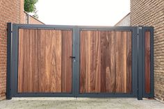 a large wooden gate in front of a brick wall with two doors on each side