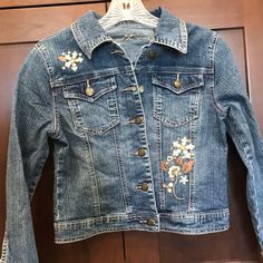 a denim jacket with embroidered flowers on it