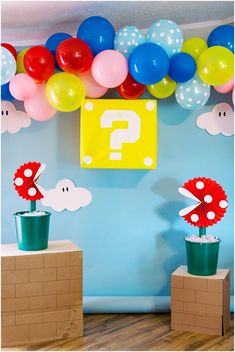 balloons and decorations are on display in front of a blue wall with question mark signs