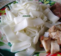 some noodles and meat are on a plate with the word sinex written in green