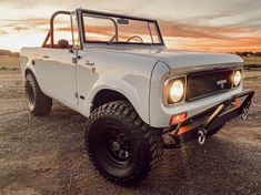 a white truck parked on top of a dirt field