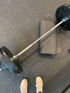 a pair of feet standing next to a barbell