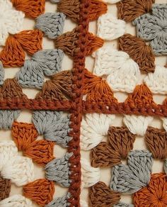 the crocheted squares are made up of different colors and shapes, including brown, gray, white, and orange