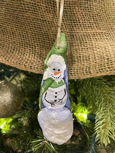 a snowman ornament hanging from a christmas tree