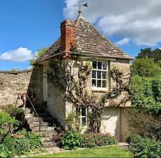 an old stone house with ivy growing on it's roof