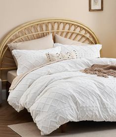 a bed with white comforter and pillows in a room