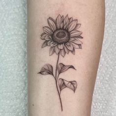 a small sunflower tattoo on the leg