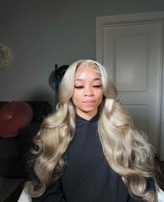 a woman with long blonde hair sitting in a chair