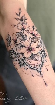 a woman's arm with flowers on it and an ornate frame around the arm