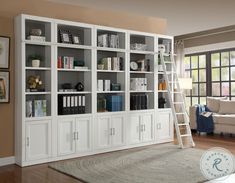 a living room with a ladder leaning up against the bookcase and books on it