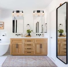 a bathroom with two sinks, mirrors and a bathtub in the middle of it