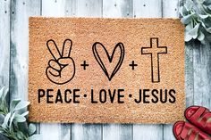 a door mat with the words peace love jesus written on it next to red shoes