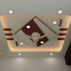 a ceiling with lights and a fan in the middle is lit by recessed lighting