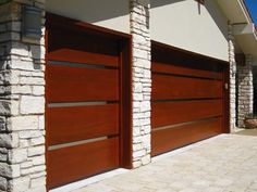 two wooden garage doors in front of a house