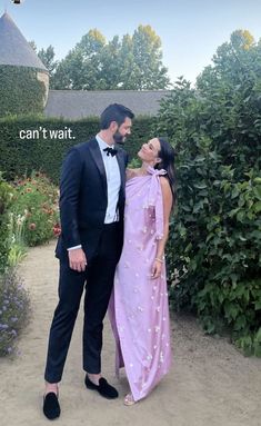 a man in a tuxedo standing next to a woman in a pink dress