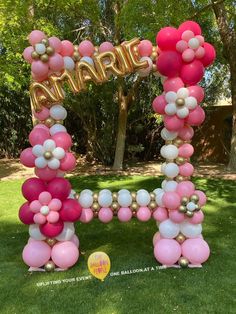 a large balloon letter made out of pink, white and gold balloons