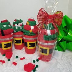 some red cups with green decorations on them and a bag full of candy in the background