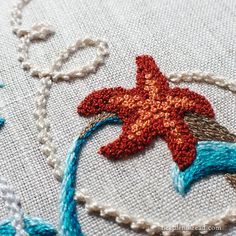 the starfish is stitched on to an embroidered piece of fabric with beads and thread