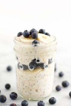 a glass jar filled with oatmeal and blueberries on top of a table