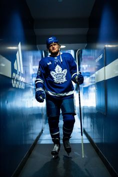 a hockey player is walking down the hallway