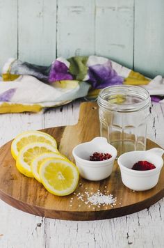 lemons, raspberries and other ingredients on a cutting board next to a jar