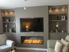 a living room filled with furniture and a flat screen tv mounted on the wall above a fire place