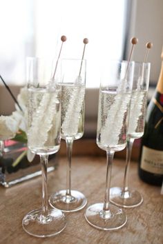 three wine glasses filled with champagne on top of a table