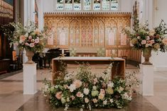 an altar with flowers and greenery in front of it