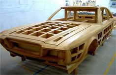 a car made out of wood sitting in a garage