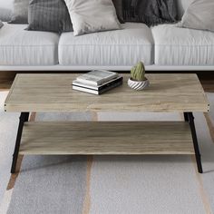 a living room with a couch, coffee table and books on the end tables in front of it