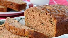 a loaf of bread sitting on top of a white plate next to some cinnamon sticks