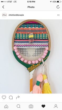 a tennis racket with pink and green decorations on it's backgroung