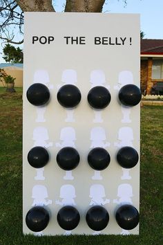 a pop the belly game is set up in the grass with black balls on it