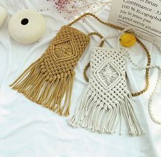 two macrame purses are laying on a white sheet next to an egg