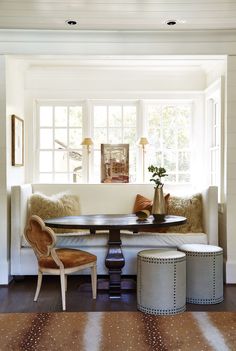 a living room filled with furniture next to a table and two chairs on top of a hard wood floor