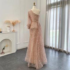 a dress on display in a room with white walls and floor to ceiling drapes