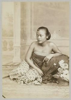 an old photo of a woman sitting on the floor