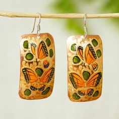 Rosy and Daniel handcraft these dangle earrings from copper. Painting freehand they depict monarch butterflies in gold orange moss green and spring green tones. Monarchs migrate each year from Canada to the fir forests of Michoacan to spend the winter. Unique Green Butterfly Earrings, Nature-inspired Green Butterfly Jewelry, Green Butterfly Nature-inspired Jewelry, Hand Painted Green Copper Jewelry, Green Hand Painted Copper Earrings, Modern Hand Painted Green Copper Jewelry, Modern Green Hand Painted Copper Jewelry, Copper Painting, Mexico Gift