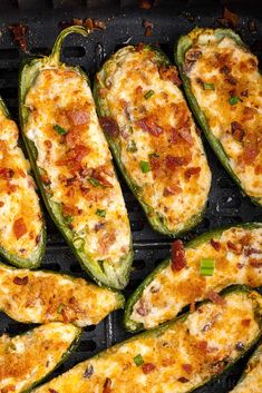 several green peppers with cheese and bacon cooking on a grill