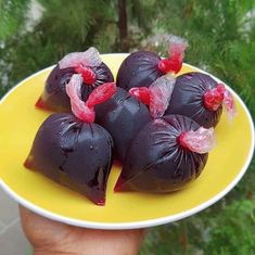 there are some fruit wrapped in plastic on a yellow and white plate with trees in the background